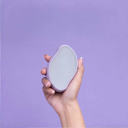 Hand holding Gleame pain-free hair removal tool in lavender color against purple background